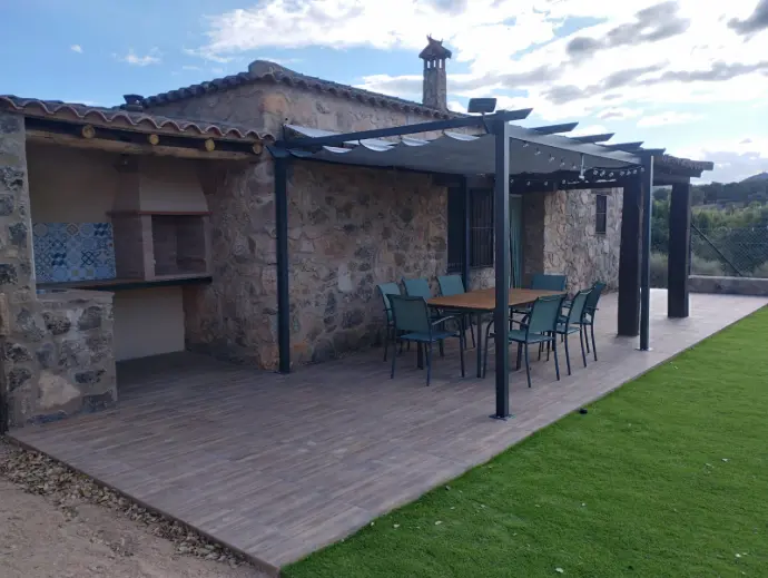 Zona de barbacoa y salón exterior con pérgola extensible